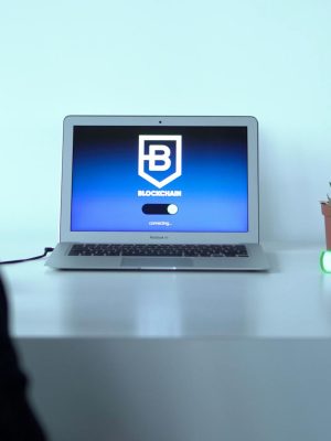 Colleagues discussing blockchain technology with a laptop in a modern office setting.